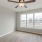 Oversized window in bedroom with ceiling fan and light fixture in homes at Lookout View Townhomes